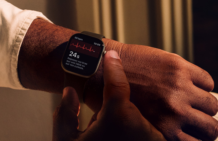 Une personne appuie de façon prolongée sur la Digital Crown d’Apple Watch Series 11 pour évaluer sa santé cardiaque dans l’app ECG