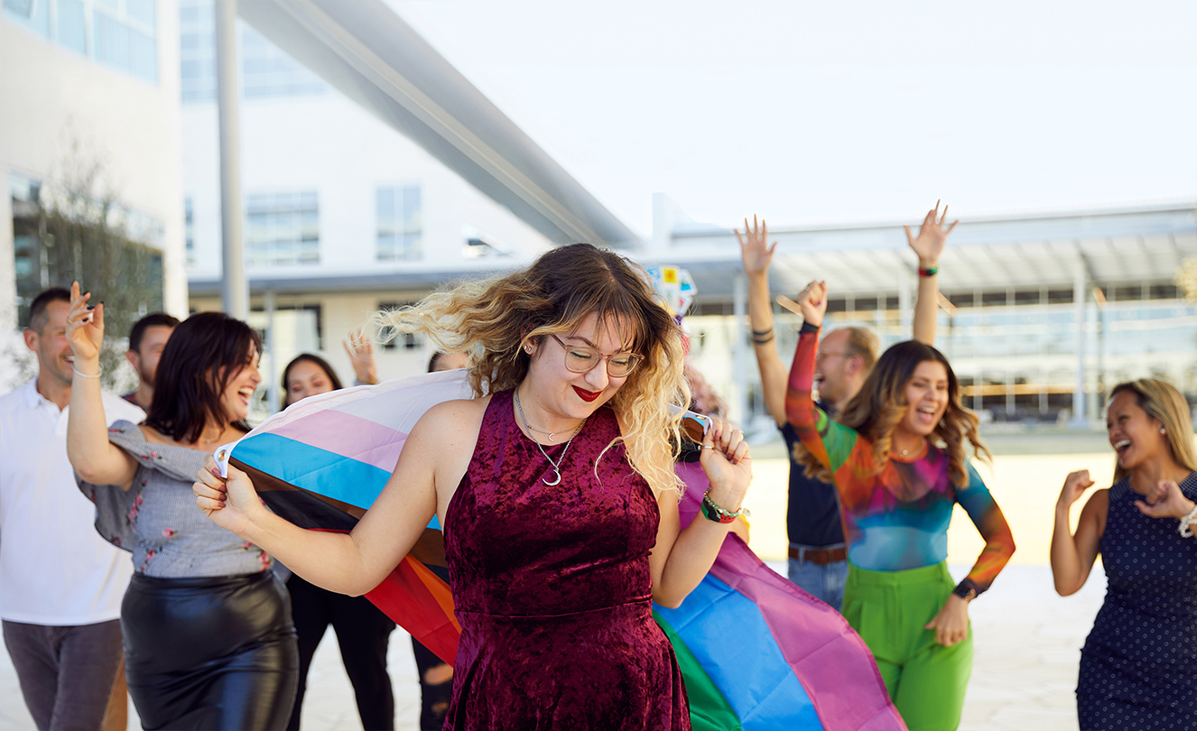 مجموعة من موظفي شركة Apple يرقصون ويحتفلون في الهواء الطلق.