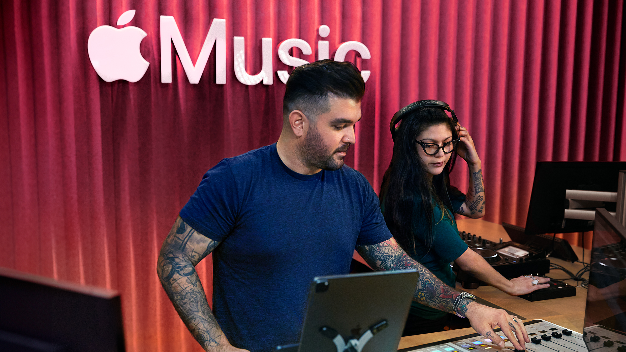 Due colleghi Apple che usano un mixer in uno studio Apple Music.