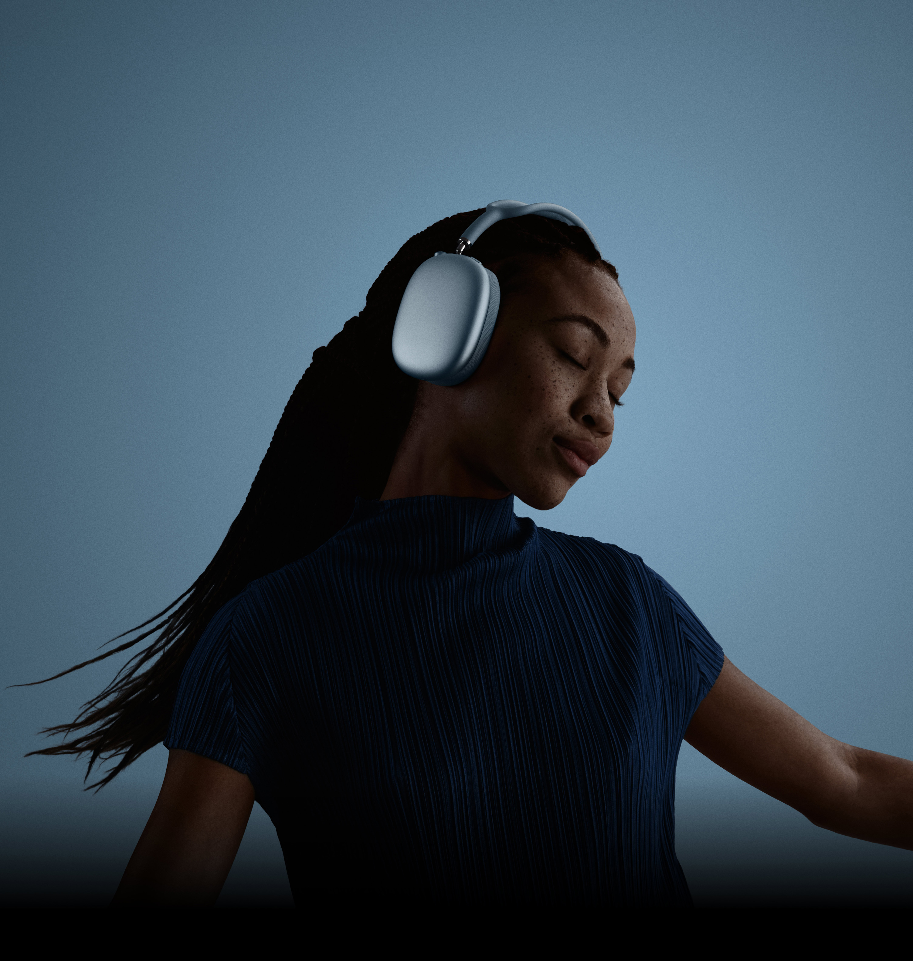 En kvinde med øjnene lukket, hovedet på skrå mod venstre og AirPods Max på hovedet.