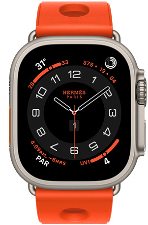 Apple Watch Hermès Ultra 3, Circulaire analog watch face, (hour, minute and second hands, complications: Weather, activity rings, Paris time and UV Index), titanium case, natural colour, right side exterior, Digital Crown, raised side button, paired with Scub'H Diving band, orange néon colour (bright orange), molded rubber material, circular cutouts centered