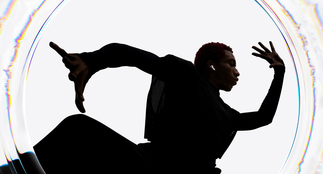 Seorang penari mengenakan AirPods Pro 3 sambil menari mengikuti irama dengan tangan terentang lebar