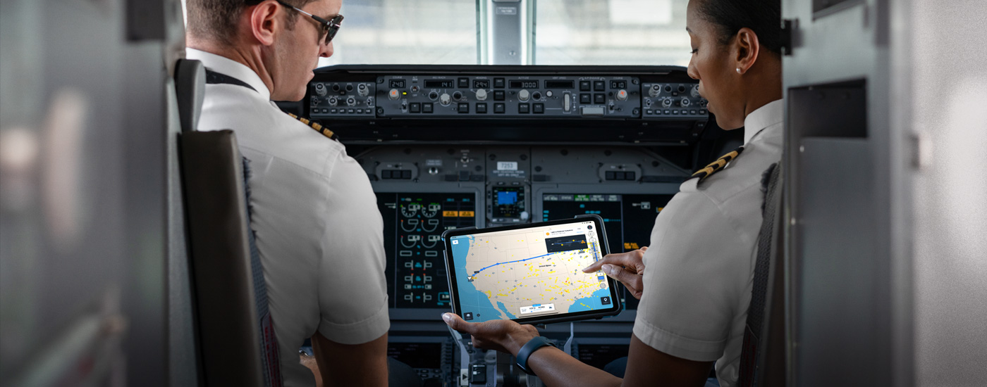 En una cabina, dos pilotos ven un mapa en la pantalla de un iPad.