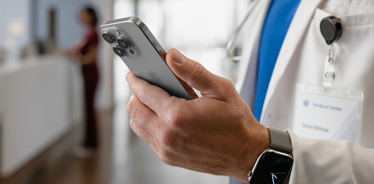 A doctor's hands hold an iPhone.