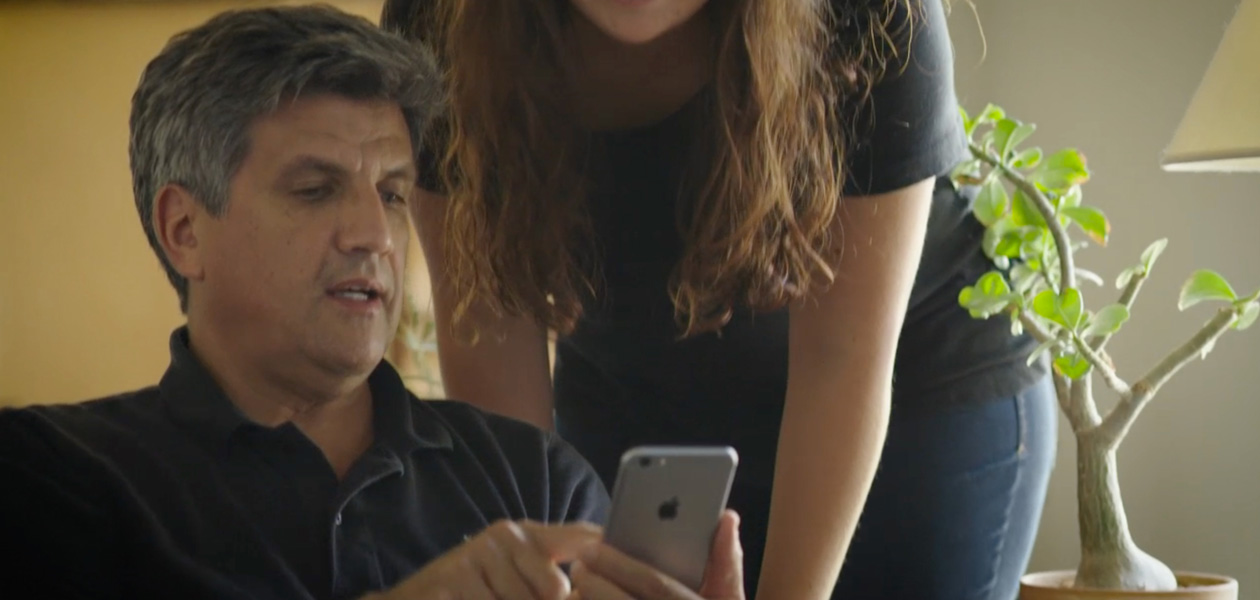 A man sharing his health information on an iPhone with the woman next to him.